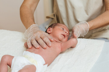 Physiotherapist performing an evaluation on a newborn baby in a therapy center.