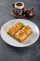 Pistachio baklava on a white plate with Turkish coffee