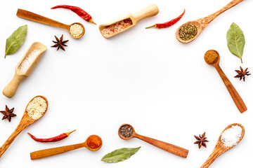 Cooking background with colorful spices and herbs in wooden spoons, top view