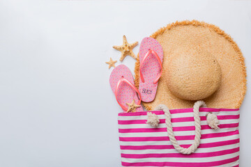 beach accessories flat lay top view on colored background Summer travel concept. Bag with starfish and sea shell. Top view