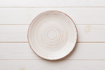 Top view of empty colorful plate on wooden background. Empty space for your design