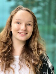 a girl of 12-15 years old looks into the frame and smiles she has a pleasant appearance...
