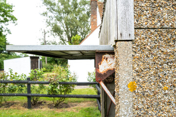 Shallow focus of a rusted metal hinge seen on an up and over garage door. Having had years of use.