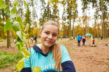 Mädchen als freiwillige Helferin beim Baum pflanzen