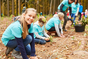 Kinder und Familie als Freiwillige beim Baum pflanzen