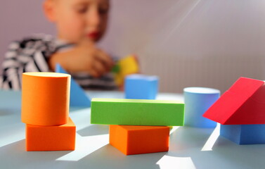 children's multi-colored geometric shapes close-up on a blue background selective focus and blurred...