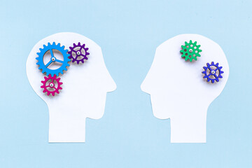 Brain work - gears on two paper human heads. Teamwork concept
