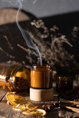 A set of different aroma candles in brown glass jars. Scented handmade candle. Soy candles are burning in a jar. Aromatherapy and relax in spa and home.
