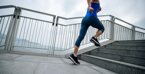 Healthy lifestyle fitness sports woman runner running up stairs on seaside trail