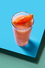 Paloma cocktail on blue and green background
