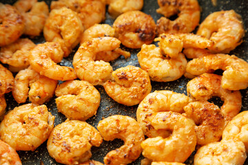 Cooking shrimps on a frypan, low angle view. Close-up.