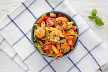 Homemade Tri-Color Penne Salad with Shrimp, Tomato and Basil Bread Crumbs in a Bowl, top view. Flat lay, overhead, from above.