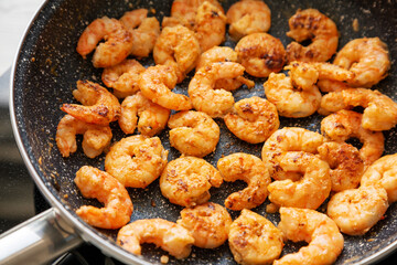 Cooking shrimps on a frypan, low angle view. Close-up.