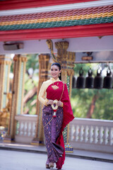 Fototapeta na wymiar Portrait of young Asian women in traditional Thai costumes worshiping Buddha images with flower garlands. Preserving the good culture of Thai people during Songkran Festival, Thai New Year, April Fami