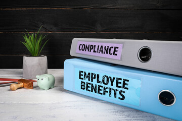  EMPLOYEE BENEFITS and COMPLIANCE. Document binders, folders on a wooden office desk