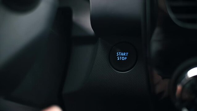 Woman presses the engine start button in the car. Slow motion