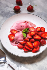 Homemade strawberry ice cream decorated with fresh berries and mint