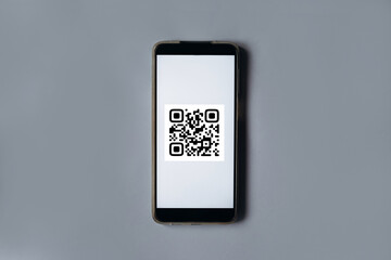 QR code scanning payment and online shopping concept. Mobile phone on the gray background.