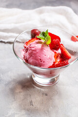 Homemade strawberry ice cream decorated with fresh berries and mint