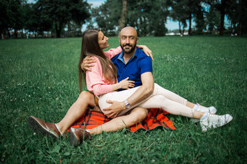 bald man hugs his beloved in meadow, concept of dating, falling in love