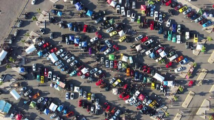 day view with drone in a car show of all kinds with a large public present attending the car show