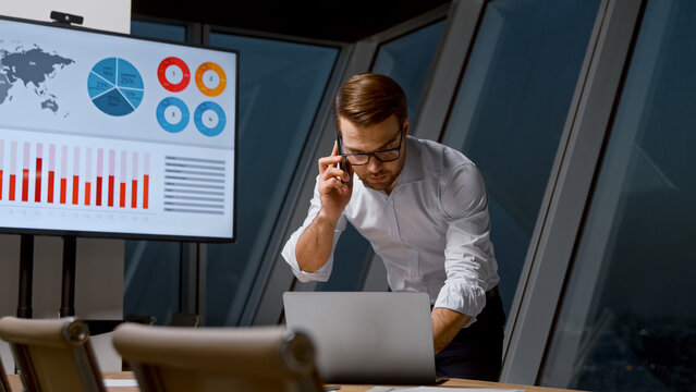 Young man communicating with a customer using a phone in workplace