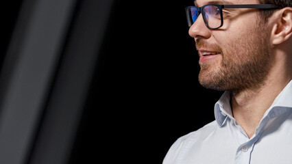 Fototapeta premium Smiling young man in eyeglasses communicating in workplace