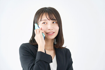 白背景でスマホで電話をする女性
