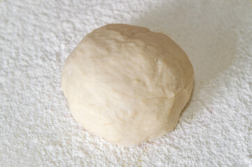 ball of dough on a background of flour