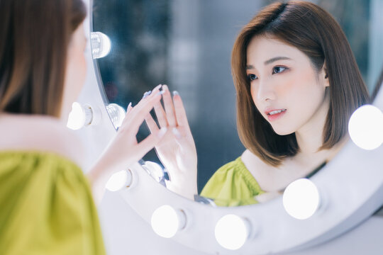 Image of young Asian girl in the front of mirror