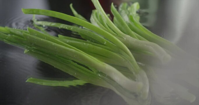 Green onion and slices fall on glass 