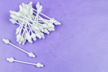 Cotton swabs with a limiter on a purple (lilac) background. Cleaning the baby's ears. Space for the text. Child care and hygiene.