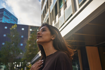 Young businesswoman looking away on sunny street