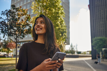 Young businesswoman with mobile phone in sun