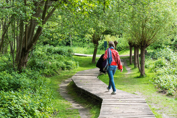 Active thrity year old woman walking a wooden trail through the Brussels wetlands