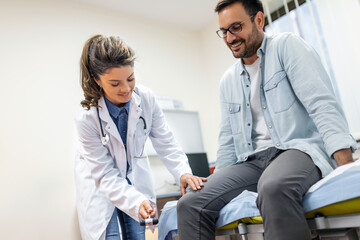 The neurologist testing knee reflex on a male patient using a hammer. Neurological physical examination. Selective focus, close up