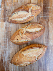 Three delicious crusted breads on a wooden board 