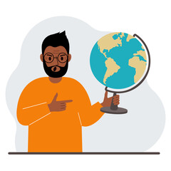 A man holds a globe in his hand and points his finger at it. The concept of education, teacher, world conquest, ecology.