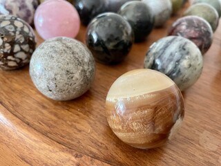 Brecciated Jasper multicolored polished crystal sphere with other - pink quartz, calcite, onyx, opal - various semiprecious stone balls for meditation, selective focus closeup. High quality photo