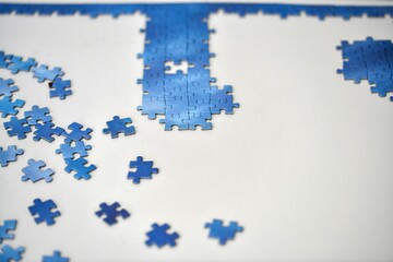 Part of the picture assembled from puzzles on a white table.