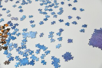 Scattered puzzles lie on the table to be assembled into a picture.