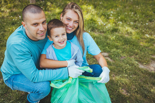 Happy caucasian Family, parents and their children together in park . Father mother and son,boy having fun and laughing outdoors. Volunteering, charity, people,ecology - Powered by Adobe