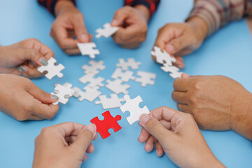 Group of business people assemble jigsaw puzzles on blue background,  teamwork, help and support in business, symbol of association and connection. business strategy.