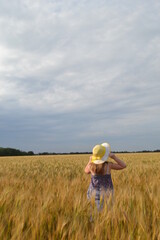 girl in a straw hat in a wheat field