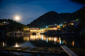 Fototapeta premium Town of Damouchari (Pelion Peninsula in Greece) at night time with reflections on the water