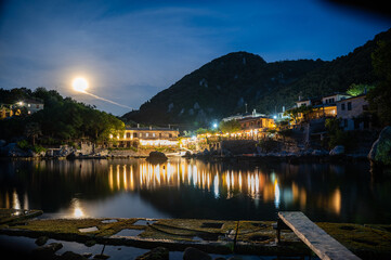 Fototapeta premium Town of Damouchari (Pelion Peninsula in Greece) at night time with reflections on the water