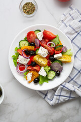 Fresh Greek salad o white plate top view