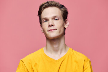 portrait of a handsome guy with freckles on a pink background