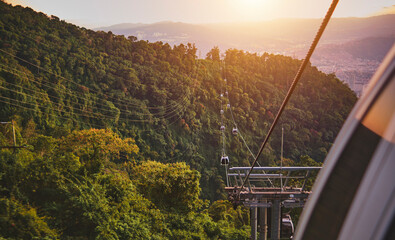 Closeup, Modular cabins cable car against the bright sky, clouds and mountains. Cableway - one of...