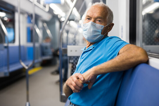 Old man in face mask sitting in subway car